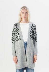 Cardigan grigio con stampa leopardata sulle spalle, apertura frontale, maniche lunghe e una texture morbida, abbinato a un semplice top bianco.