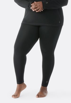 Leggings neri realizzati in materiale elasticizzato, con una vestibilità aderente e dettagli di cucitura discreti. Un'etichetta piccola con accenti colorati vicino alla caviglia.