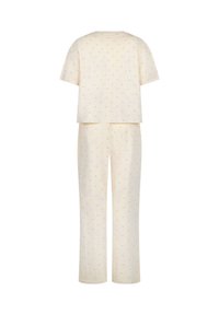 Cream-colored two-piece outfit with short-sleeve top and straight-leg pants, featuring a subtle small print pattern throughout.