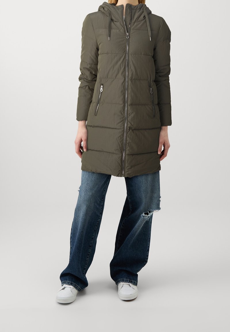 Kaki puffjacka med huva, dragkedjestängning och två sidofickor. Har horisontell sömnad och en lätt, något glänsande yta.