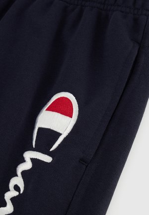Pantaloni della tuta blu navy con logo ricamato bianco e accento rosso e bianco. Tessuto morbido, vita elasticizzata e tasche laterali.