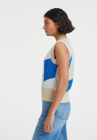 Sleeveless knitted sweater featuring a geometric pattern in blue, beige, and light blue. Ribbed bottom hem, soft texture.