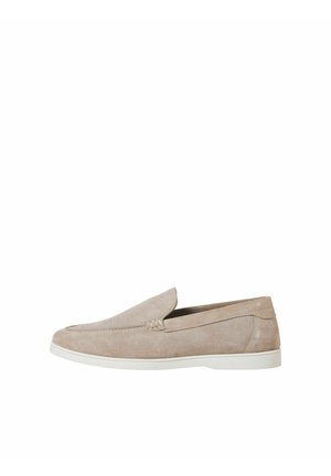 Lichtbeige suède loafer met witte zool, instapmodel en subtiele, gestikte details langs de zijkanten en voorkant.