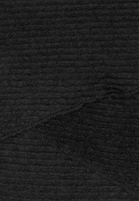 Black textured fabric with a soft, fuzzy surface. Features a subtle ribbed pattern and a stitched edge, creating a layered look.