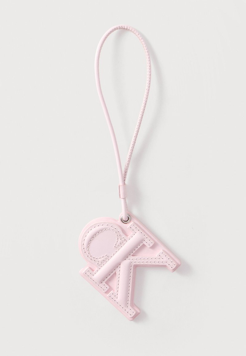 Porte-clés en cuir rose clair avec les lettres "CK" embossées et une sangle boucle assortie sur fond blanc.