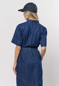 Džínové šaty s krátkými rukávy, páskem v pase s červenobílým zdobením a rovným střihem. Tmavě modrá látka, neformální design.