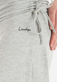 Graue Baumwoll-Jogginghose mit Seitentaschen, gerafft am Bund und mit Kordelzugverschluss. Mit dem „Winshape“-Logo in schwarzem Stick.