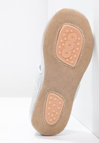 Sølv barnesko såle med en myk beige suedes overflate og gummigrep-dotter, med en sydd kant.