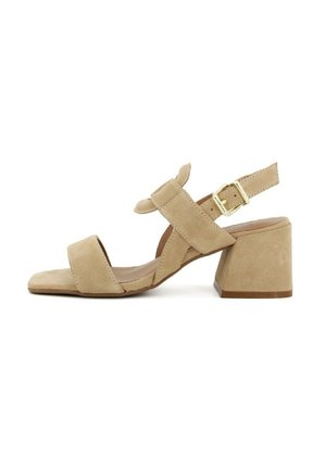 Sandali in suede beige con tacco a blocco, due fasce anteriori e una fascia alla caviglia. Presentano una fibbia dorata per la chiusura e un design a punta quadrata.