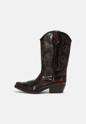 Botte de cowboy en cuir marron foncé avec une couture noire complexe, hauteur mi-mollet, bout carré et talon bas empilé sur fond blanc.