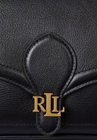 Musta nahkalaukku, jossa on teksturoitu pinta, kaareva läppämuotoilu ja kultainen logo, jossa on kirjaimet "RLL."