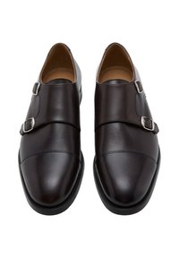 Scarpe in pelle marrone scuro con doppia fibbia argento, punta arrotondata, texture liscia e design minimalista. Suole piatte.