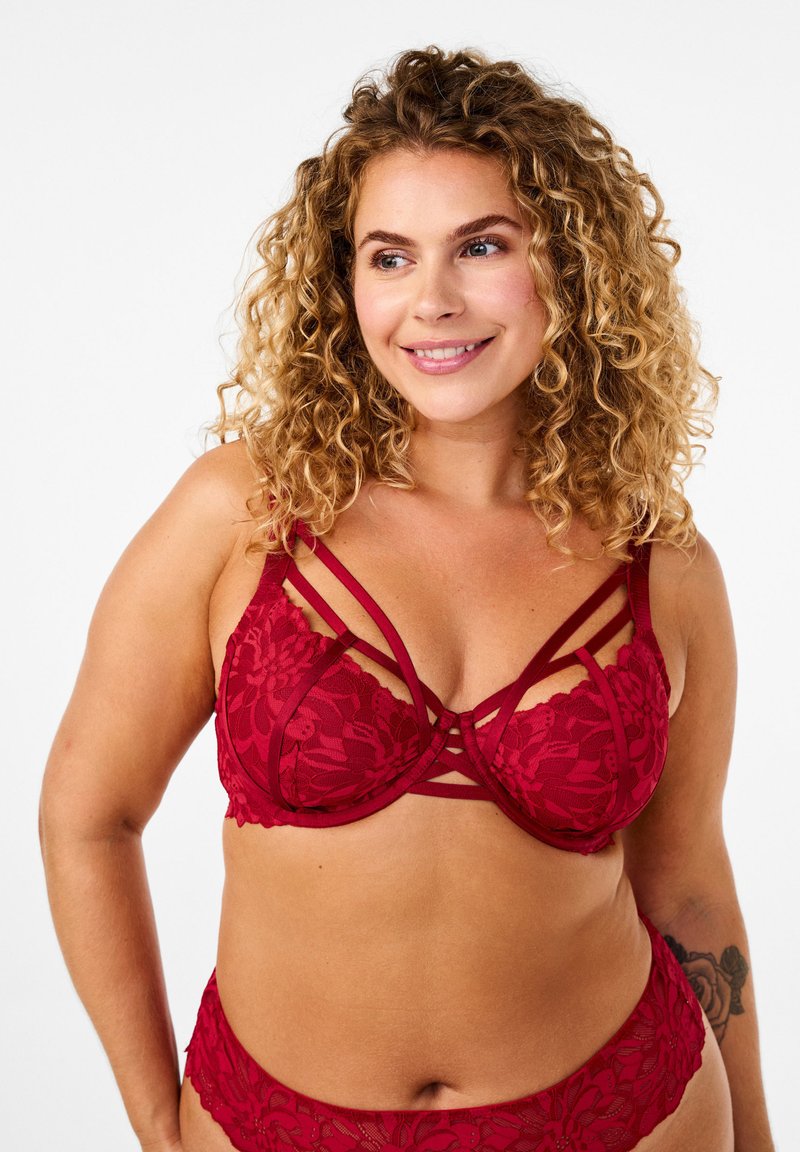 Rød blondetop med stropdesign, blomster mønstre og matchende blondebikini. Har justerbare stropper og blød tekstur.