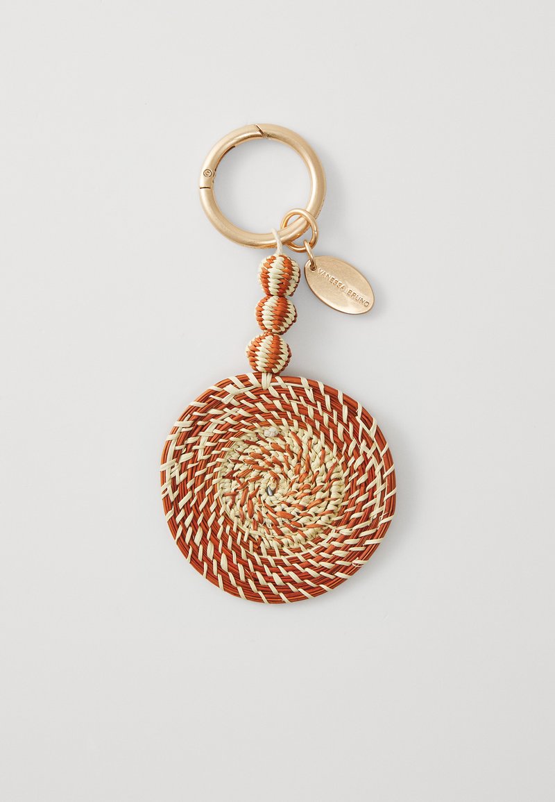 Vævet nøglering i spiraldesign med orange og beige nuancer. Inkluderer tre strukturerede perler og en ring i guldfarvet metal.
