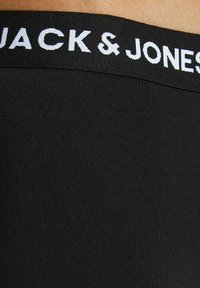 Schwarze Boxershorts für Männer mit einem strukturierten Bund, der den Markennamen "JACK & JONES" in weißen Buchstaben zeigt. Glattes Material, körpernaher Schnitt.