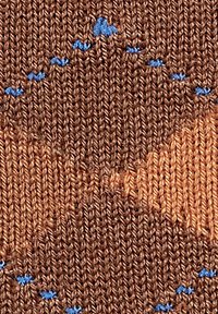 Tessuto a maglia con un motivo testurizzato in marrone con accenti azzurri; forme geometriche creano un design a contrasto in tutto il tessuto.