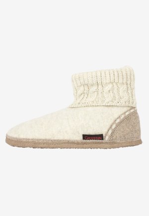 Wollen pantoffels met een gebreide crèmekleurige rand, beige zool en gestikte details. Bevat een zwart etiket met "Giesswein" in het rood.