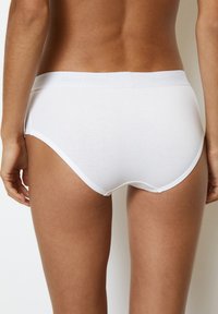Witte katoenen slip met een gladde textuur, voorzien van een zachte tailleband met een reliëf van "Marc O’Polo." Eenvoudig, klassiek ontwerp.