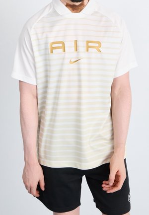 Maglietta polo Nike con design a righe bianche e giallo chiaro, con grande logo "AIR" dorato e piccolo logo Nike swoosh. Maniche corte, colletto.