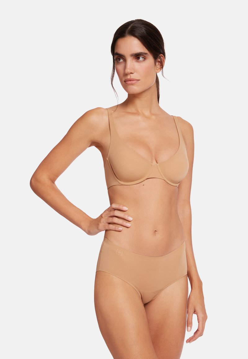 Nude sømløs bh og panties sæt i glat stof, med et elegant design, justerbare stropper og minimalistiske detaljer.