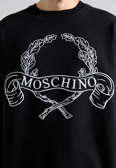Schwarzer Sweatshirt mit weißem gesticktem Lorbeerkranz und gekreuzten Ästen, mit dem Text "MOSCHINO" auf einem geschwungenen Banner auf der Vorderseite.