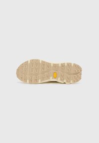 Beige Sneaker-Sohle mit einem robusten Profil und einem zentralen gelben Logo. Die Textur ist gummiartig, ideal für Grip und Langlebigkeit.