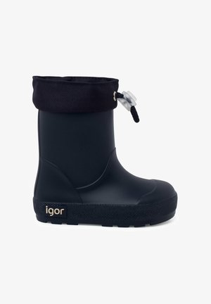 Botte de pluie en caoutchouc noir avec une semelle texturée. Présente un revers en tissu bleu marine avec un cordon de serrage. Logo visible sur le côté.