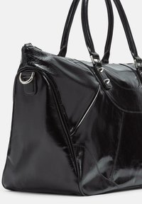 Schwarze, glänzende Lederhandtasche mit doppelten Griffen, silbernem Metallring an der Seite und dekorativen silbernen Nieten an den vorderen Riemen.