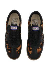Sneaker nere con dettagli in stampa leopardata, caratterizzate da una tomaia texutizzata, punta rotonda e lacci neri. Etichetta di branding sulla linguetta.