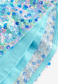 Tissu bleu superposé avec des sequins colorés, présentant une base en maille et un dos lisse, bordé d'un point soigné le long des bords.