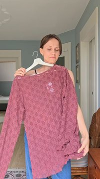 Bordeauxfarbene Spitzen-Bluse mit langen Ärmeln und floralem Muster; weiter Ausschnitt; leichtes Material; fällt sanft mit einem asymmetrischen Saum.