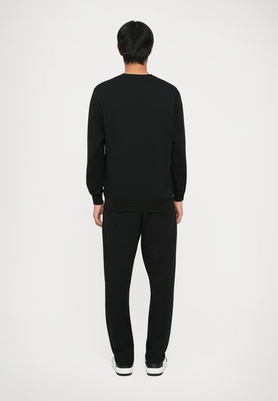 Completo felpa nera e pantaloni realizzato in tessuto morbido, con maniche lunghe, collo rotondo e polsini e orlo a costine. Design semplice.
