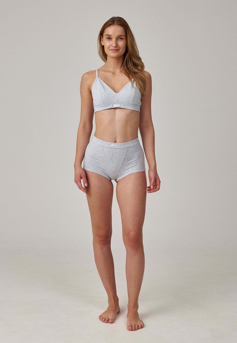 Graue Baumwoll-Bralette und passendes, hochgeschnittenes Unterwäsche-Set. Das Bralette hat verstellbare Träger, eine glatte Textur und minimale Nähte.