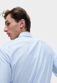 Lichtblauw gestreept shirt met een rugpand, button-down kraag en een soepele textuur. De stof heeft verticale witte strepen.