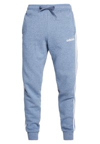 Modré bavlněné tepláky s elastickým pasem, šňůrkou, bočními kapsami a bílými pruhy po stranách. Obsahují logo Adidas na bocích.