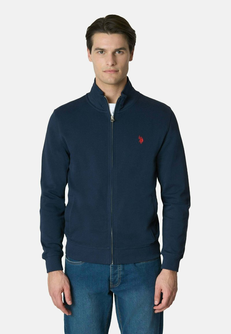 Giacca zip-up blu navy realizzata in tessuto misto cotone, con colletto rialzato, polsini a coste e un piccolo logo rosso sul lato sinistro del petto.