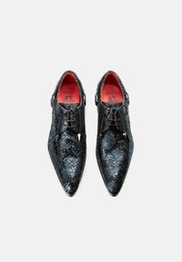 Zwarte slangenleren schoenen met puntige neuzen, voorzien van zilveren accenten, een vetersluiting en rode binnenzolen. Opmerkelijke branding aan de binnenkant.