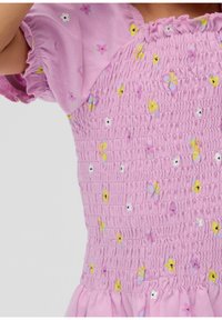Rosa Kleid mit gerafftem Oberteil, kurzen Puffärmeln und verstreuten Blumenmustern in Gelb, Lila und Weiß. Weicher Stofftextur.