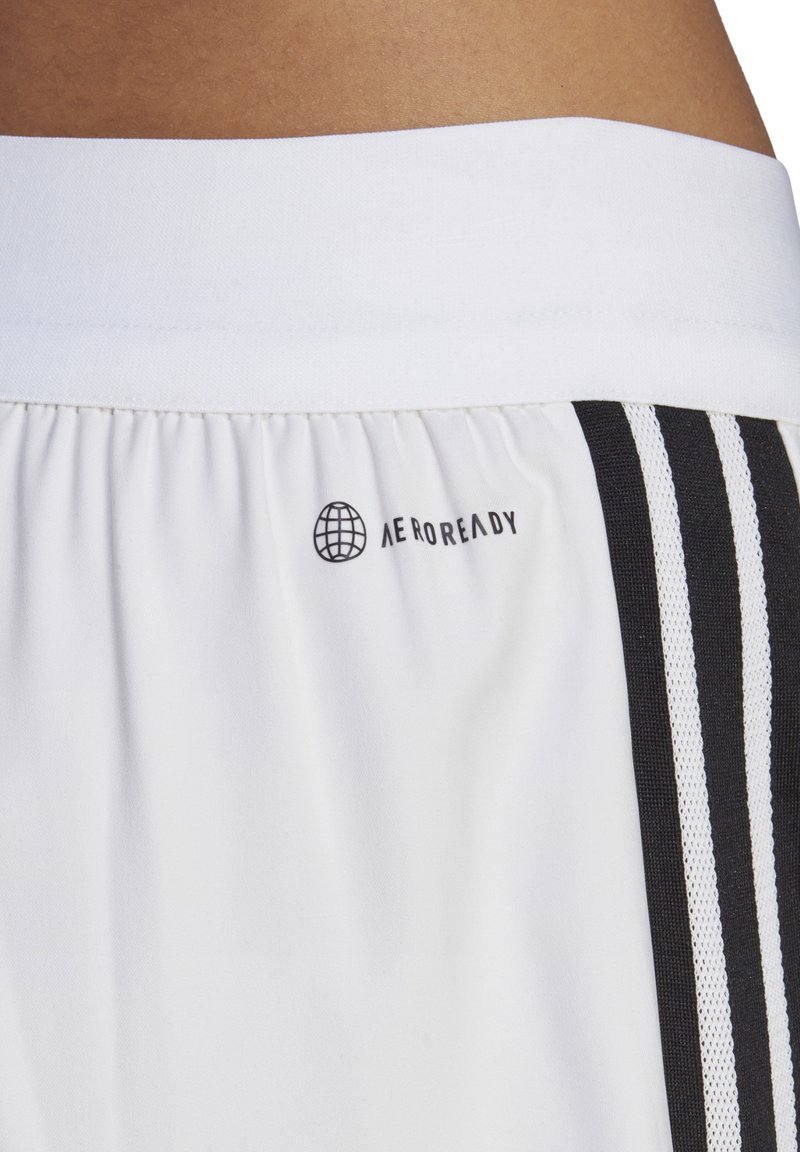 Shorts de sport blancs avec une taille élastique noire, ornés d'un logo noir "AEROREADY" et de rayures latérales noires avec des accents texturés.