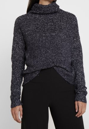 Trui met een colnek, gemaakt van gestructureerd marineblauw materiaal met lichte kleurvlekken. Heeft lange mouwen en een iets verkorte voorkant.