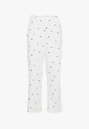 Witte broek met een elastische tailleband, voorzien van een overal patroon van kleine groene bladeren en rode stippen. De stof heeft een gladde textuur.