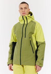 Grüne und gelbe wasserdichte Jacke mit Kapuze, Reißverschlusstaschen und kontrastierenden schwarzen Akzenten. Glatte Textur, atletische Passform und Belüftung.