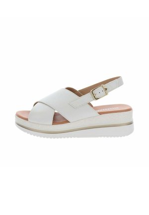 Sandalo slingback in pelle bianca con cinturini incrociati, fibbia dorata, soletta imbottita color cuoio e suola piattaforma bianca con grip testurizzato.