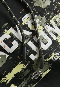 Felpa nera con stampa a macchie bianche e verdi, caratterizzata da testo audace e coulisse nera con accenti gialli e terminali in plastica.