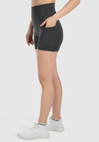 Hoge zwarte shorts met een gladde textuur, voorzien van zijzakken en een nauwsluitend ontwerp, geschikt voor actieve kleding.