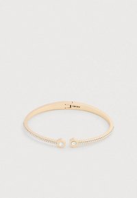 Az arany színű fém karperec hatszögletű díszítésekkel, két tiszta drágakővel és egy sor apró kristállyal az egyik oldalán.