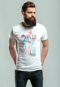 Weißes T-Shirt mit grafischem Druck, der Palmen in Pink und Blau zeigt. Der Text lautet "NVRLSS Surf Co" und "Pazifische Inseln." Enganliegendes Design.