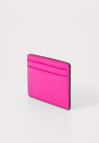 Różowy skórzany portfel na karty o teksturowanym wykończeniu. Posiada cztery kieszonki na karty oraz kontrastowe czarne krawędzie. Kompaktowy i smukły design.