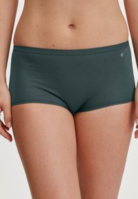 Donkergroene katoenen boxershorts met een naadloze tailleband en een gladde textuur, voorzien van een klein logo aan de linkerkant.