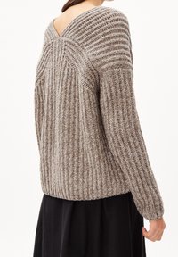 Pull en maille côtelée crème et marron avec un dos en V et des manches longues, confectionné dans un tissu doux et texturé.
